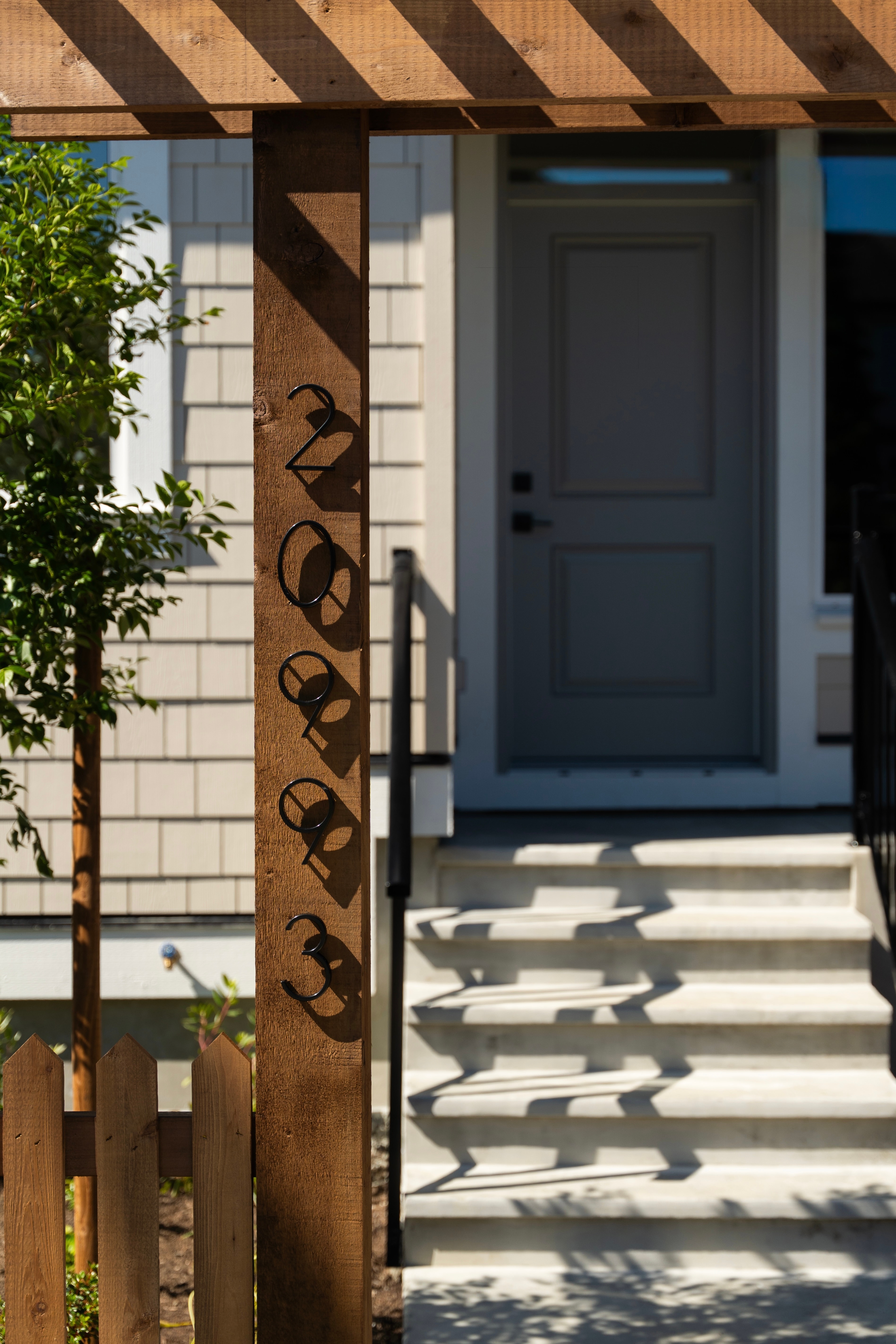 House number detail mounted on a cedar pergola post at a completed Willoughby Row home