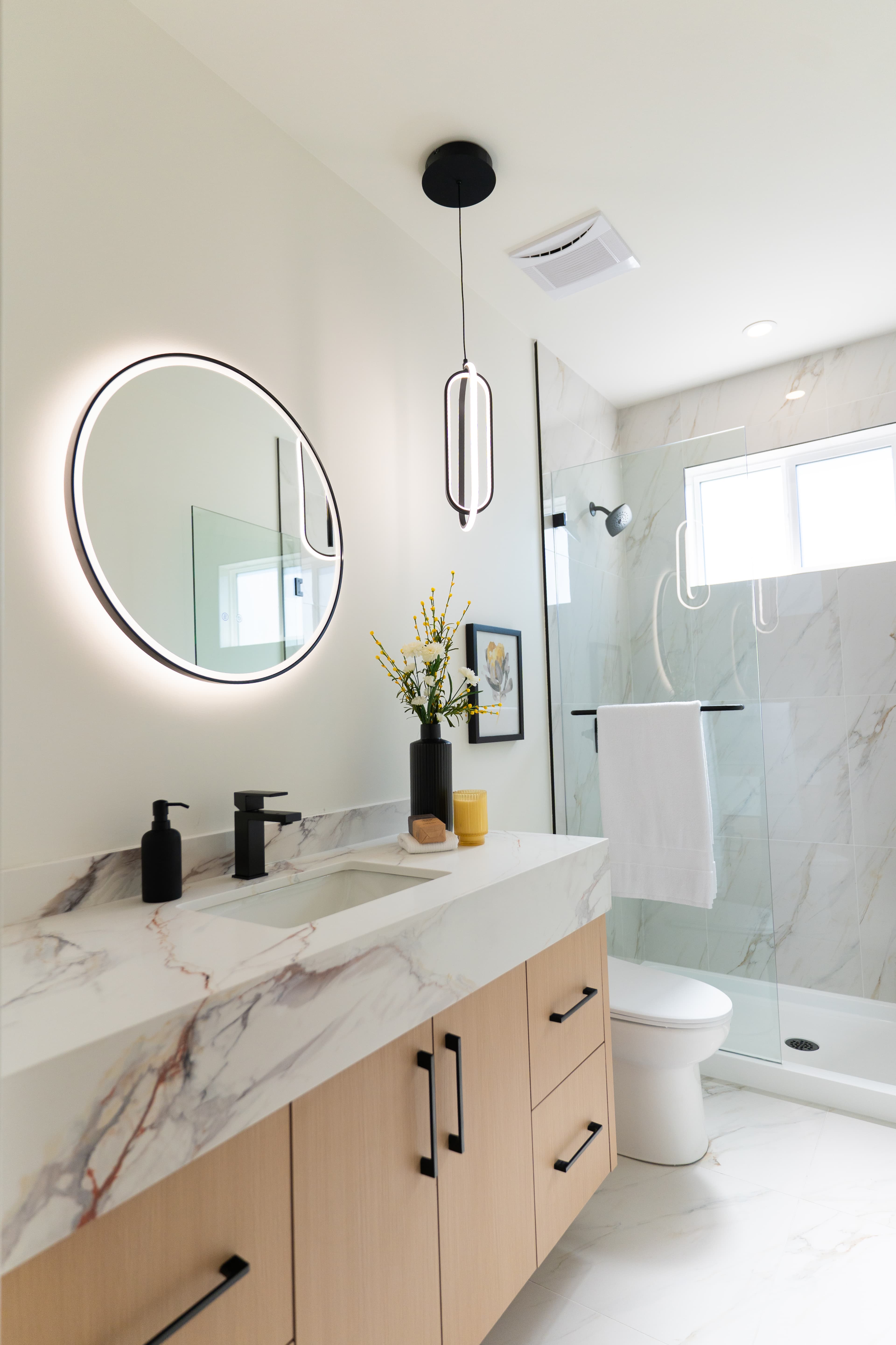 Second bathroom at Willoughby Row with round mirror and marble-look counter