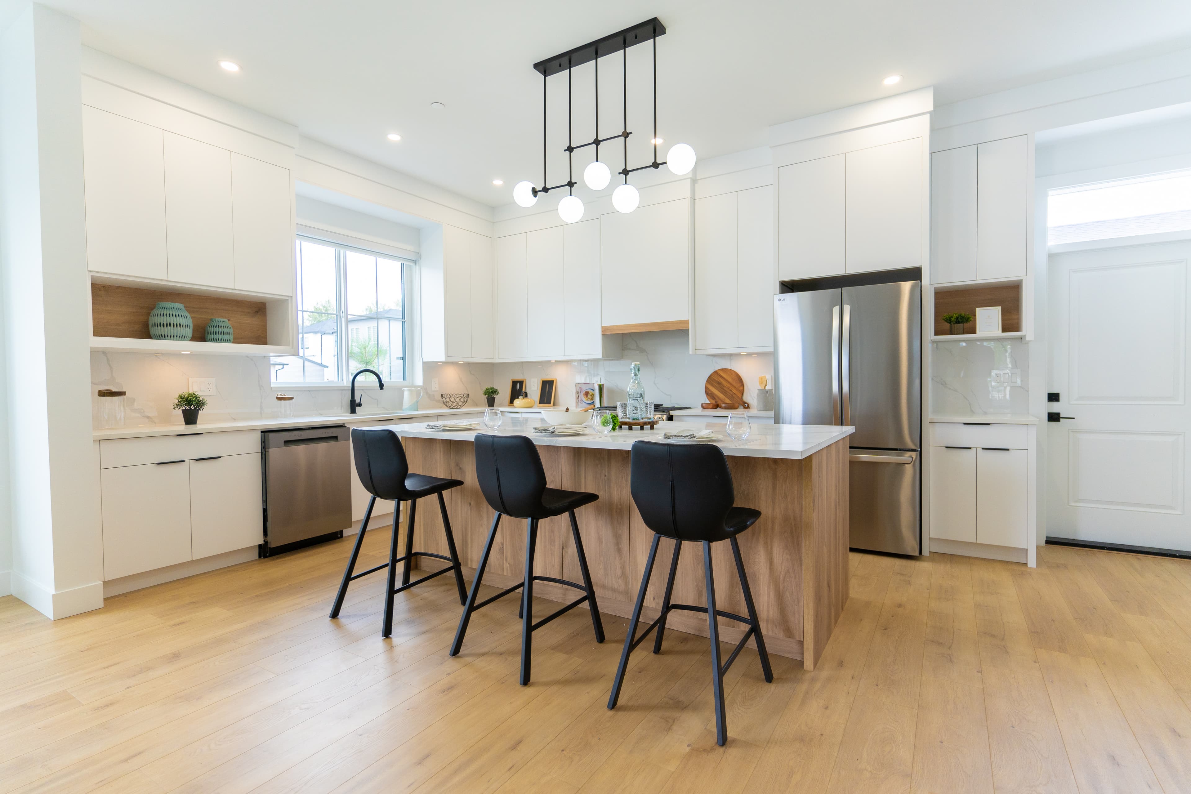 Bright white kitchen at Willoughby Row with gas range and marble-look backsplash