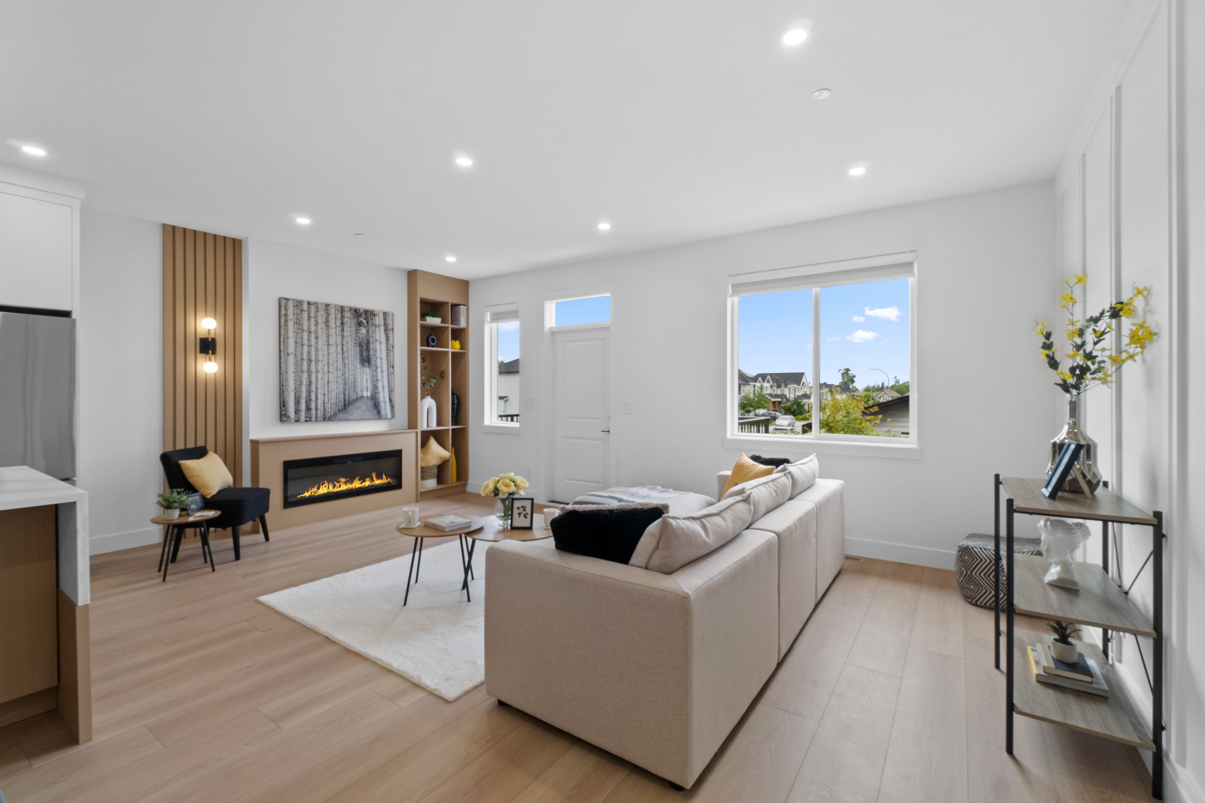 Open-concept living room at Willoughby Row with built-in fireplace and wood-panelled wall