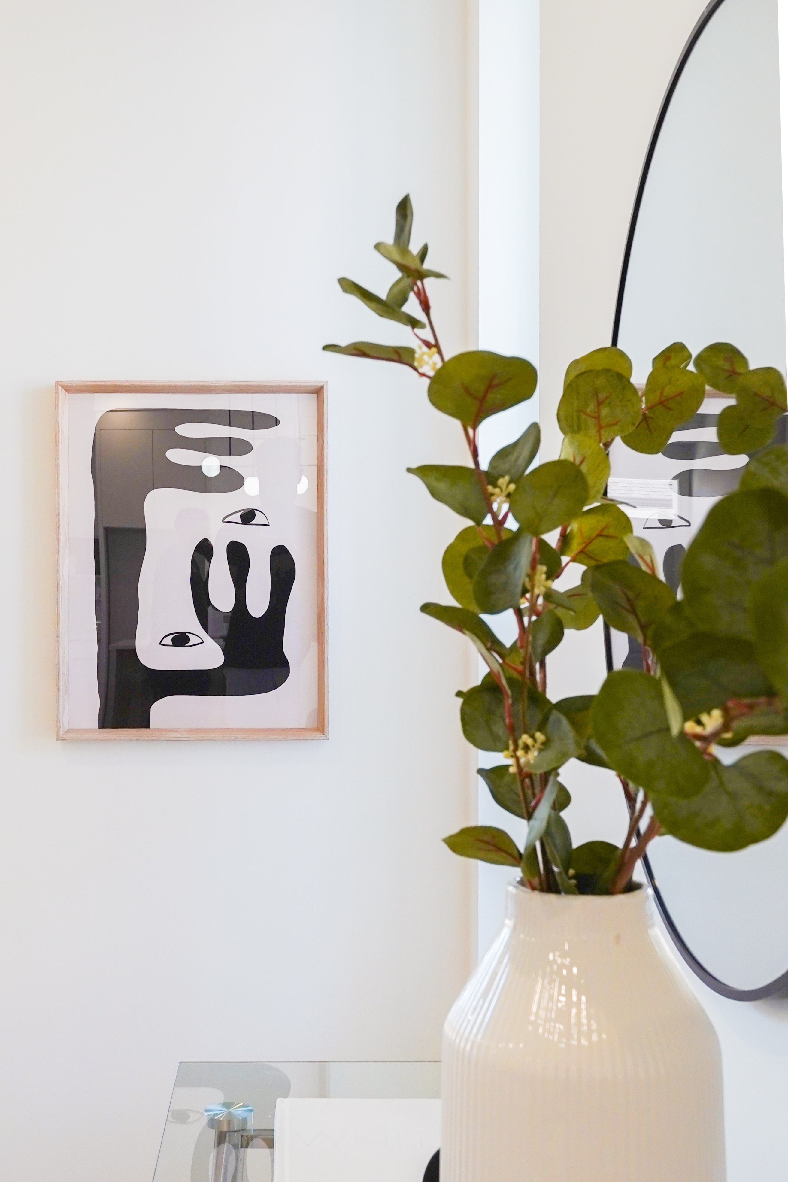 Living room wall detail at Willoughby Row with framed artwork and eucalyptus branch